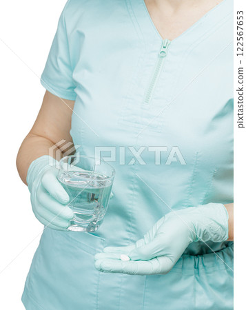 Hands of a female doctor with a glass of water and a capsule. Hands of a female doctor with a glass of water and a capsule. 122567653