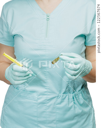 Female physician in gloves holding a syringe and an ampoule with medicine. Female physician in gloves holding a syringe and an ampoule with medicine. 122567674