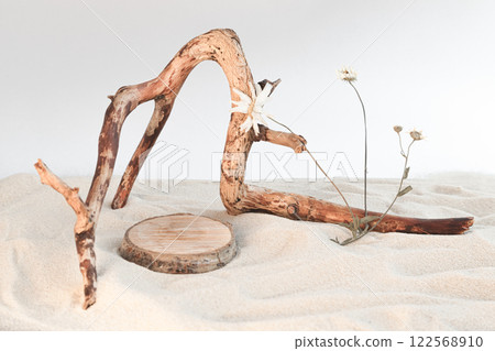 A dry tree branch and rocks on a background of beach sand. Minimalistic creative composite background for the presentation of cosmetics or products. Front view A dry tree branch and rocks on a background of beach sand. Minimalistic creative composite background for the presentation of cosmetics or products. Front view 122568910