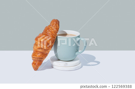 Fresh croissant and up of cappuccino or latte coffee on a marble stands on a green background 122569388