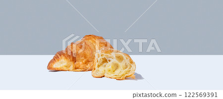 Fresh broken croissant on white gray background with shadow. Fresh broken croissant on white gray background with shadow. 122569391