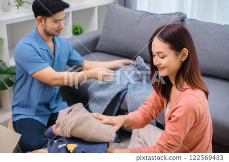 group of friend sorting and packing clothes into a donation box.community support, and charitable giving group of friend sorting and packing clothes into a donation box.community support, and charitable giving 122569483