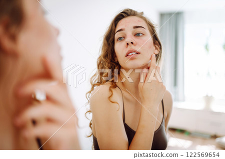 Beautiful woman with acne problem skin checks dry face skin. Red spots, rash, acne. Skin treatment. Beautiful woman with acne problem skin checks dry face skin. Red spots, rash, acne. Skin treatment. 122569654