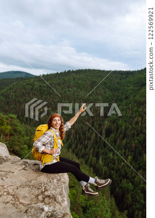 Woman on mountain peak. Landscape with sporty young woman, green hills. Nature. Travel and tourism. 122569921