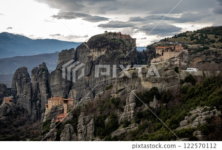 There is a collection of buildings that is located on a rocky mountain top There is a collection of buildings that is located on a rocky mountain top 122570112