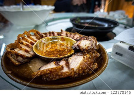 Close up of fried pork belly with spicy orange powder to dip in. China 122570146