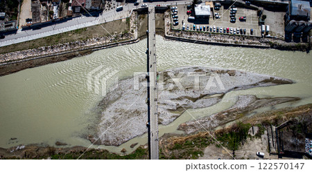 90 degree take over Berat oldest bridge with river and people crossing. Albania 122570147