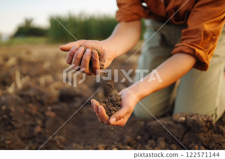 Expert hand of farmer woman checking soil health before growth seed of vegetable. Gardening concept. Expert hand of farmer woman checking soil health before growth seed of vegetable. Gardening concept. 122571144