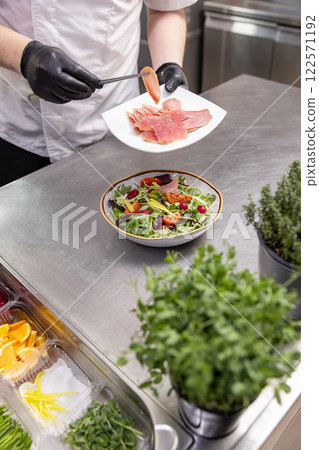 Chef adding smoked salmon 122571192
