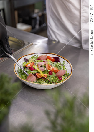 Chef preparing a healthy salad with smoked salmon 122571194