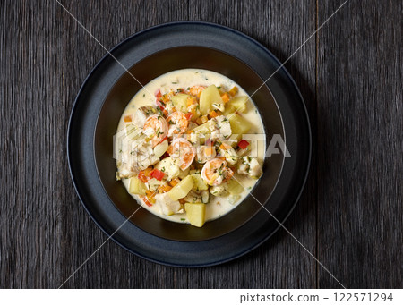 seafood chowder in a white bowl, top view 122571294
