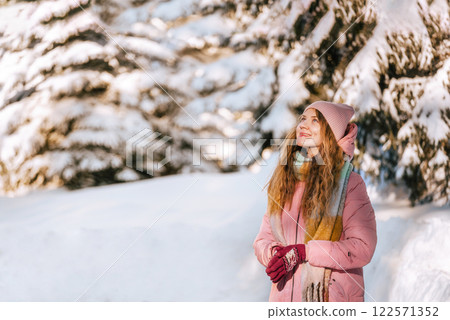 Smiling Woman Enjoying Walk in Winter Forest 122571352