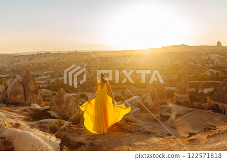 Woman stands on mountain with flying air balloons on background. Tourist Turkish region Cappadocia. 122571818