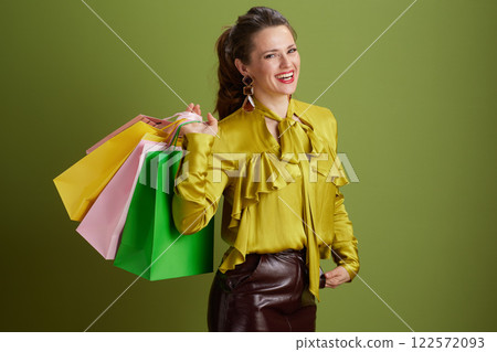 happy trendy woman in green blouse isolated on green background 122572093