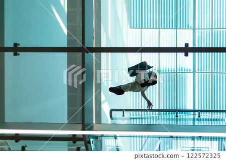 Bottom view through a transparent glass floor of a woman in a modern business center. Modern architecture 122572325