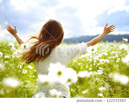 Woman enjoying freedom in a field of daisies Woman enjoying freedom in a field of daisies 122572507