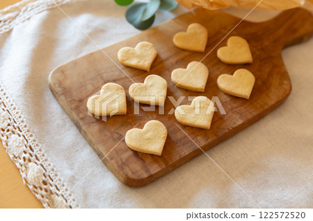 Heart-shaped homemade cookies lined up on a wooden board 122572520