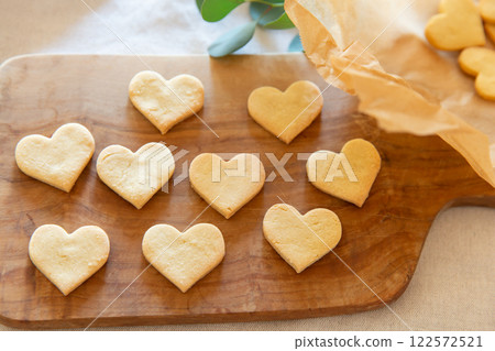 Heart-shaped homemade cookies lined up on a wooden board 122572521