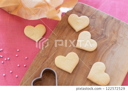 Heart-shaped homemade cookies lined up on a wooden board Heart-shaped homemade cookies lined up on a wooden board 122572529