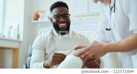 basketball player receiving treatment for knee injury, smiling happily 122572894