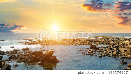 Seascape with beautiful waves, rocky shore and bright sunrise. Concept - vacation and travel. 122574527