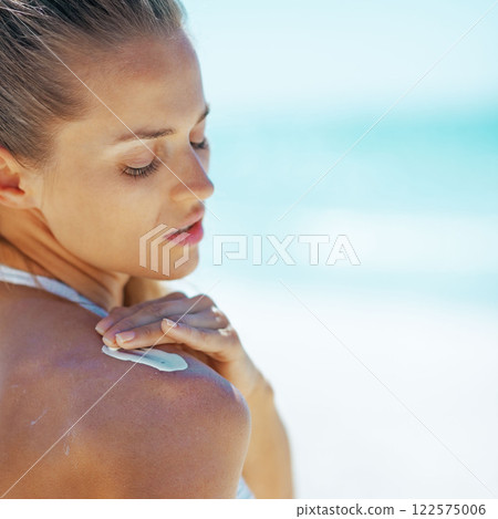 Young woman applying sun screen creme 122575006