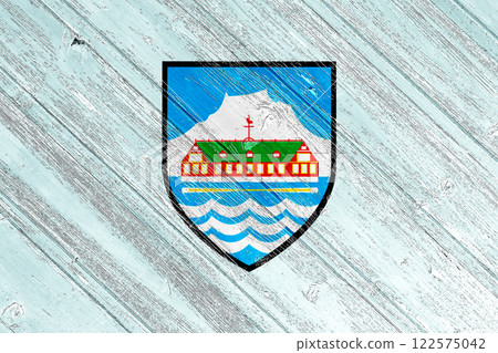 Official flag and coat of arms of Nuuk. Greenland. Conceptual collage on wood texture 122575042