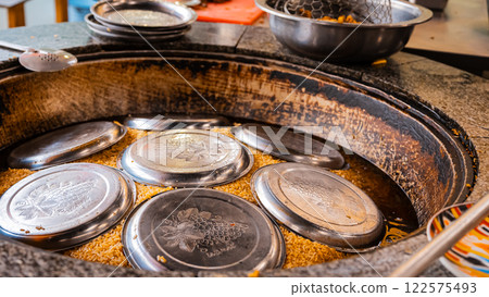 The concept of oriental cuisine. Assorted Uzbek food set, pilaf, samsa, lagman, manta, shurpa central asia food. Homemade Uzbek pilaf or plov from lamb served in cast iron cookware 122575493