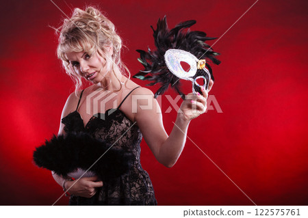 Woman holding carnival mask feather fan in hand 122575761