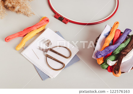 Set of equipment for cross stitching on a gray background Set of equipment for cross stitching on a gray background 122576163