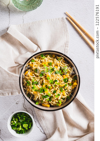 A bowl of instant noodles and vegetables on the table top and vertical view 122576191