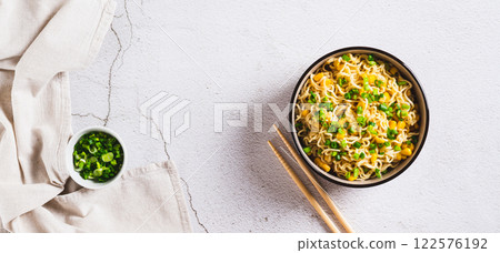 A bowl of instant noodles and vegetables on the table top view web banner A bowl of instant noodles and vegetables on the table top view web banner 122576192