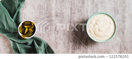 Spicy sour cream sauce with garlic in a bowl on the table top view web banner 122576201