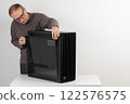 Man removing  tempered-glass left panel from  PC case, empty big tower, chassis. 122576575