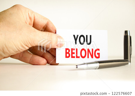 Belonging and you belong symbol. Concept words You belong on beautiful white card. Beautiful white background. Businessman hand. Business belonging and you belong concept. Copy space. Belonging and you belong symbol. Concept words You belong on beautiful white card. Beautiful white background. Businessman hand. Business belonging and you belong concept. Copy space. 122576607