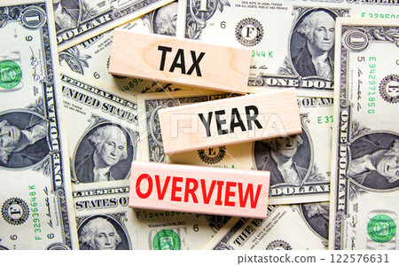 Tax year overview symbol. Concept words Tax year overview on beautiful wooden blocks. Dollar bills. Beautiful background from dollar bills. Business tax year overview concept. Copy space. Tax year overview symbol. Concept words Tax year overview on beautiful wooden blocks. Dollar bills. Beautiful background from dollar bills. Business tax year overview concept. Copy space. 122576631