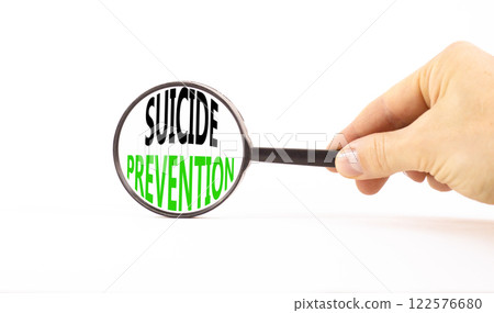 Suicide prevention symbol. Concept words Suicide prevention on beautiful magnifying glass. Beautiful white table background. Psychologist hand. Psychological suicide prevention concept. Copy space. 122576680