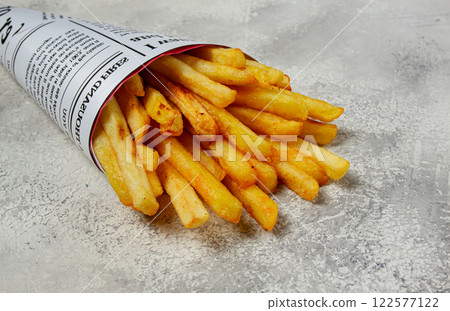 Fried French fries in a paper bag, on an abstract background, without people, in a rustic style, 122577122