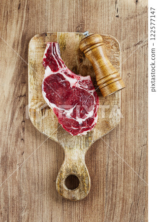 raw rib eye steak, cowboy steak, on a wooden chopping board, top view, no people, raw rib eye steak, cowboy steak, on a wooden chopping board, top view, no people, 122577147