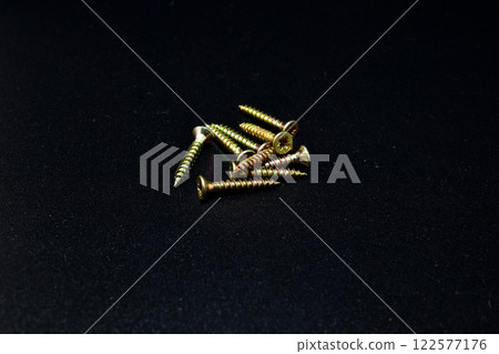 Several screws are lying in a pile on the table. 122577176