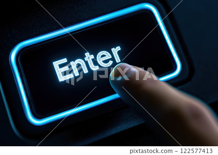 Illuminated Blue Enter Key on Black Keyboard with Finger Pressing Button 122577413