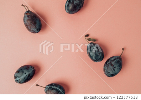 Top view photo of whole plums on isolated pastel pink background Top view photo of whole plums on isolated pastel pink background 122577518