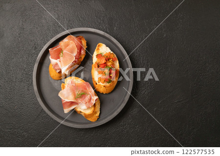 Tasty bruschetta served with wine on gray background 122577535