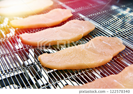 Pieces of meat on conveyor belt machine Pieces of meat on conveyor belt machine 122578340