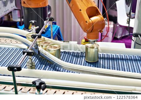 Robotic arm and cans on conveyor 122578364