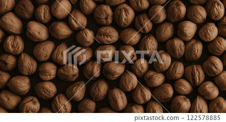Walnuts background texture. Many brown nuts close-up view. Food blog, cookbook, or packaging design. Flat lay overhead shot, dark brown background 122578885