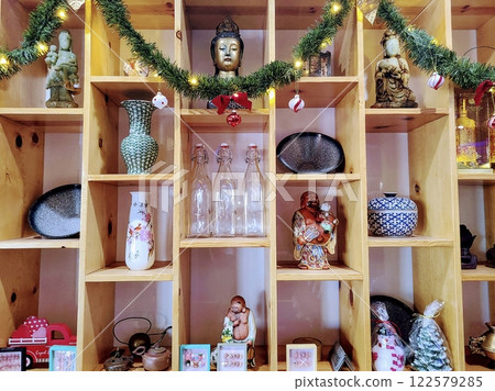 Cozy Festive Buddha Decor on Shelves with Warm Holiday Glow Eye-Level View Cozy Festive Buddha Decor on Shelves with Warm Holiday Glow Eye-Level View 122579285