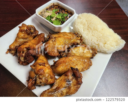 Crispy Thai Chicken Wings with Sticky Rice and Dipping Sauce Eye Level View Crispy Thai Chicken Wings with Sticky Rice and Dipping Sauce Eye Level View 122579320