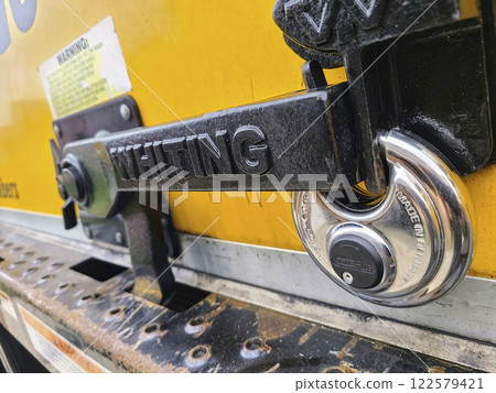 Industrial Yellow Door Lock Mechanism Close-Up Eye-Level Perspective Industrial Yellow Door Lock Mechanism Close-Up Eye-Level Perspective 122579421