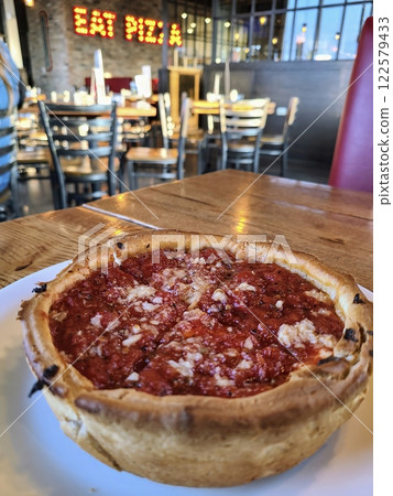 Deep-Dish Pizza in Cozy Pizzeria Setting Eye-Level View 122579433
